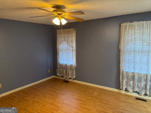 2395 High Falls Road Griffin, GA 30223 - Photo 16 of 20 en empty room with windows and chandelier fan