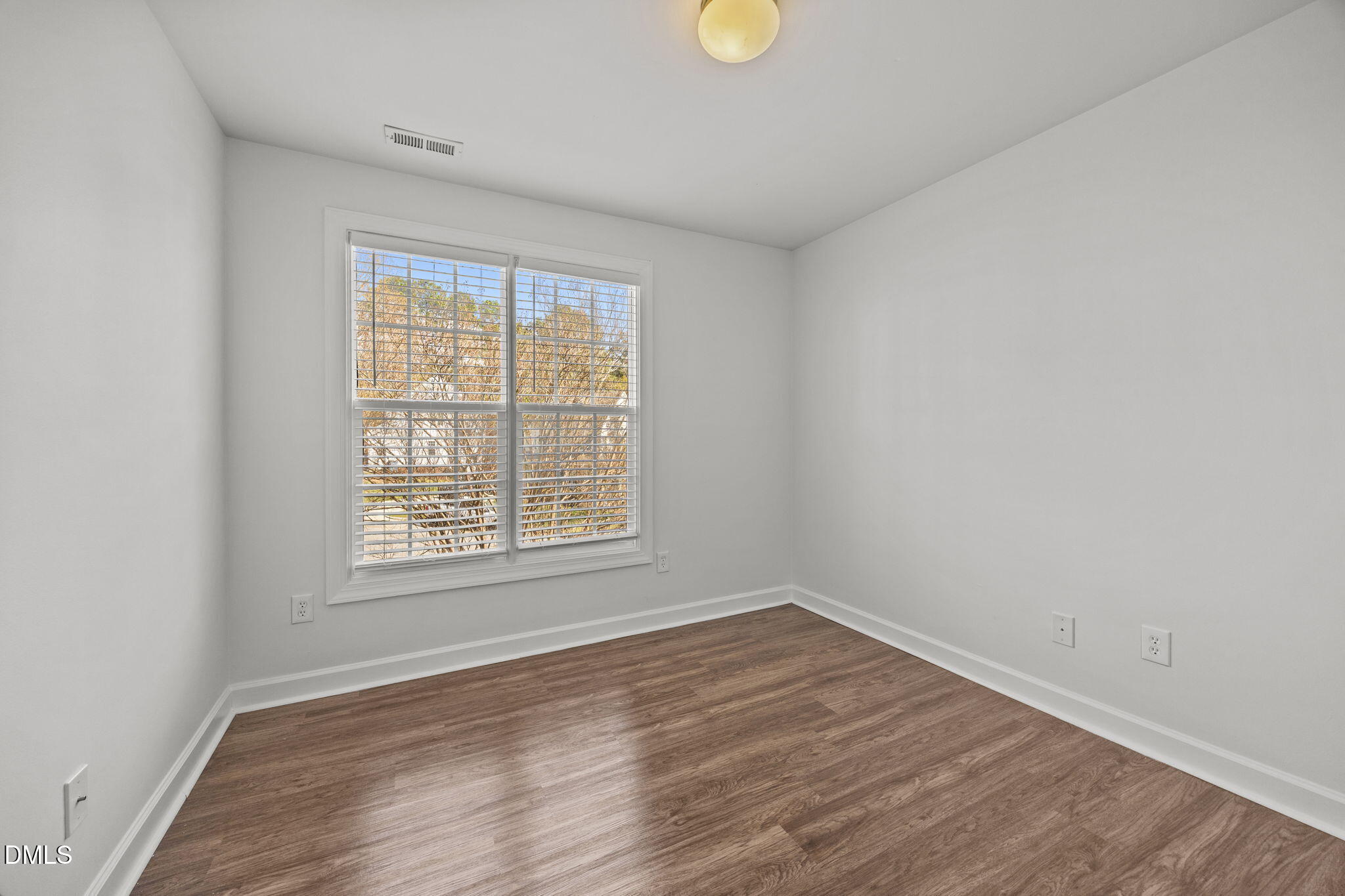 9220 Pennythorne Court Raleigh, NC 27615 - Photo 24 of 49 an empty room with wooden floor and windows