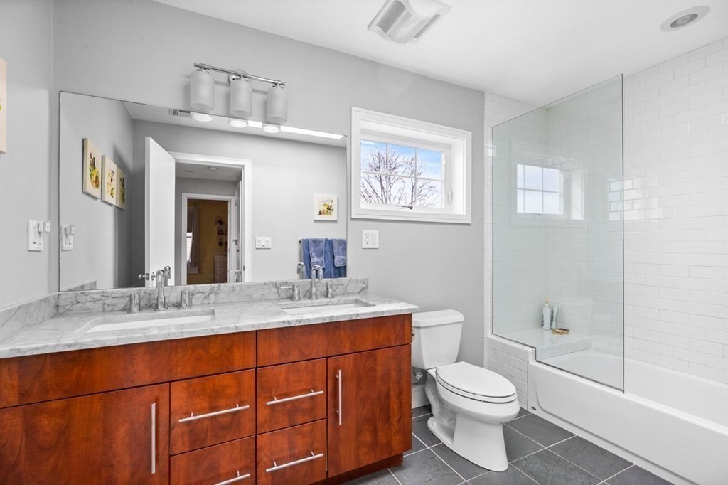 80 Summit Avenue, Unit 80 Brookline, MA 02446 - Photo 28 of 41 a bathroom with a granite countertop toilet sink and mirror