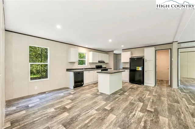 a large white kitchen with a sink and refrigerator