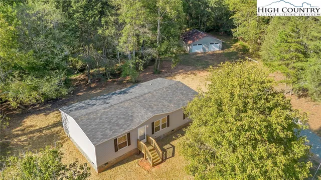 a aerial view of a house with swimming pool and large trees