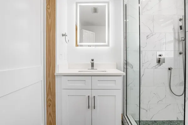 a bathroom with a shower sink and mirror