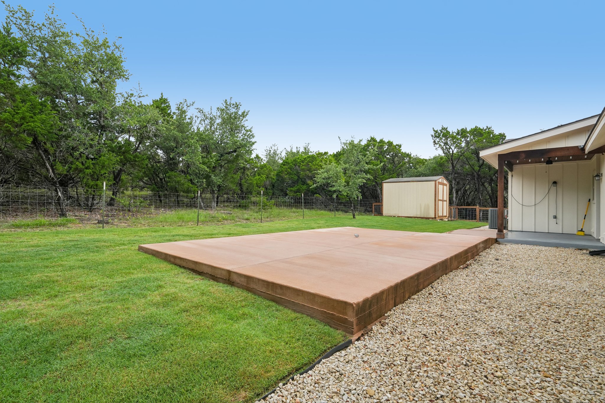 190 Magnolia Meadow Spring Branch, TX 78070 - Photo 20 of 29 A spacious concrete patio extends from the home, offering ample outdoor living space amidst a verdant backyard.