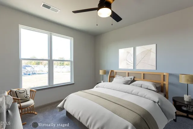 a kitchen with stainless steel appliances granite countertop a stove a sink a refrigerator white cabinets wooden floor and a large window