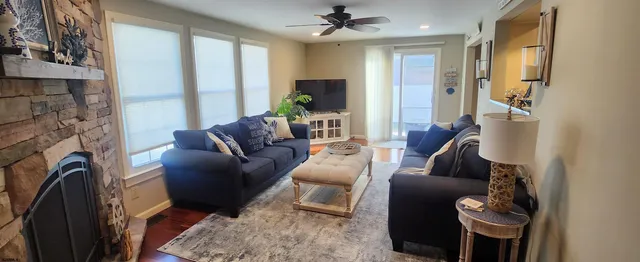 a living room with furniture a flat screen tv and a fireplace