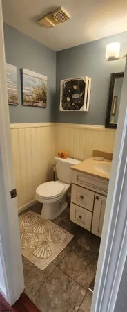 a bathroom with a toilet a sink a mirror and vanity