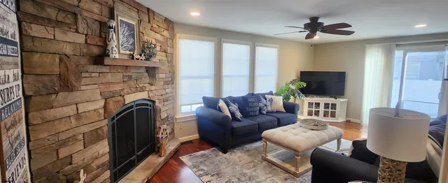 a living room with furniture a flat screen tv and a fireplace