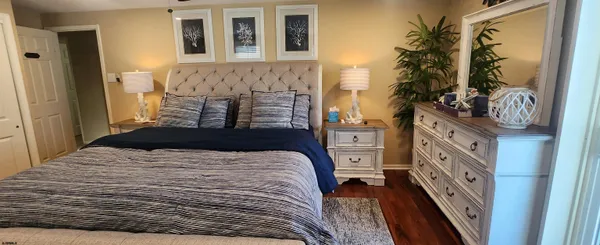 a bedroom with a bed and a large mirror on the dresser