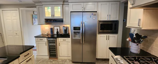 a kitchen with stainless steel appliances granite countertop a refrigerator and a stove top oven