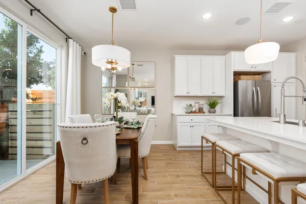 a kitchen with a dining table chairs sink and cabinets