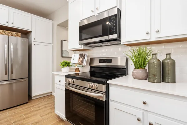 a kitchen with stainless steel appliances a stove a microwave and a refrigerator
