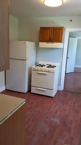 a kitchen with cabinets and a refrigerator