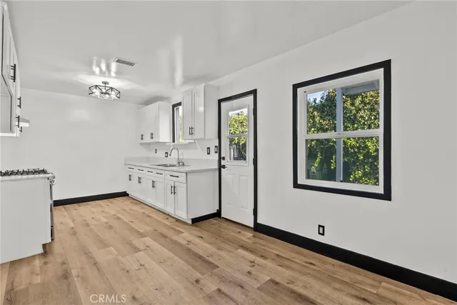 a view of a kitchen with a sink cabinet and a chandelier