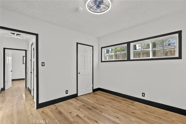 a view of empty room with wooden floor and window