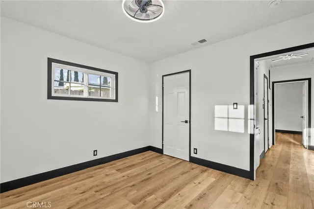 a view of empty room with wooden floor