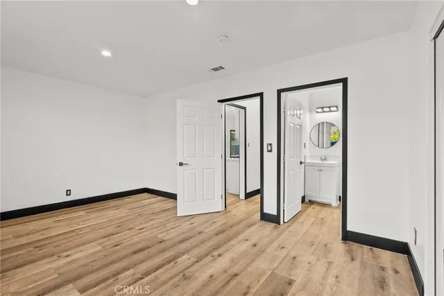 a view of a hallway with wooden floor and closet area