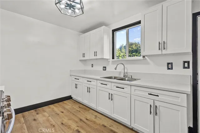 a kitchen with stainless steel appliances granite countertop white cabinets a sink and a window