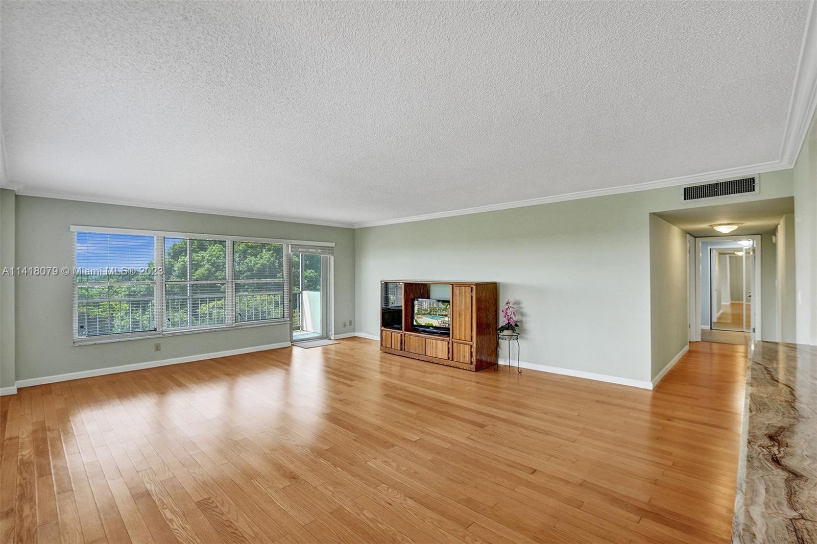 10777 West Sample Road, Unit 614 Coral Springs, FL 33065 - Photo 15 of 40 a view of an empty room with wooden floor and a window