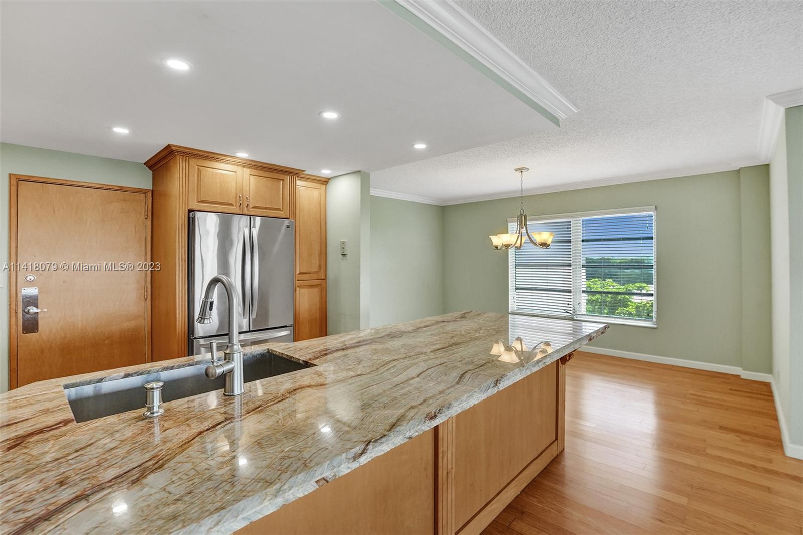 10777 West Sample Road, Unit 614 Coral Springs, FL 33065 - Photo 17 of 40 a large hall with stainless steel appliances granite countertop a sink and a large mirror of wooden cabinet