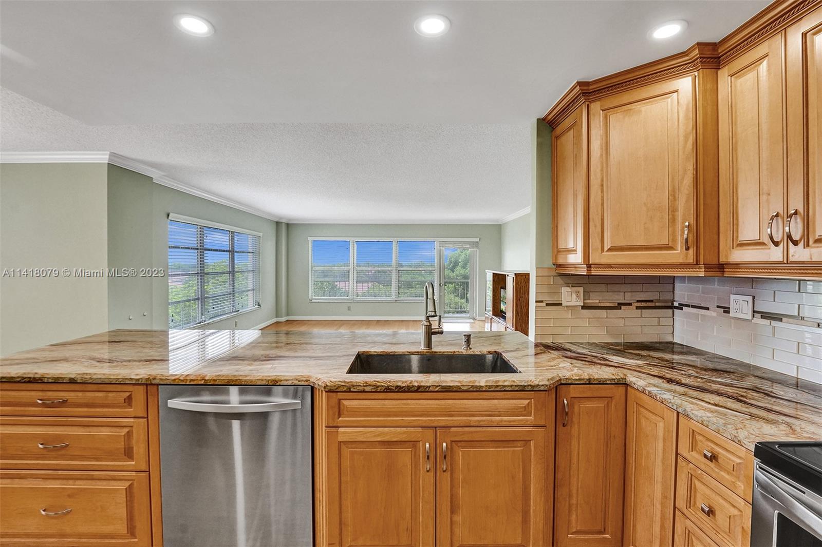 10777 West Sample Road, Unit 614 Coral Springs, FL 33065 - Photo 20 of 40 a kitchen with stainless steel appliances granite countertop a sink and cabinets