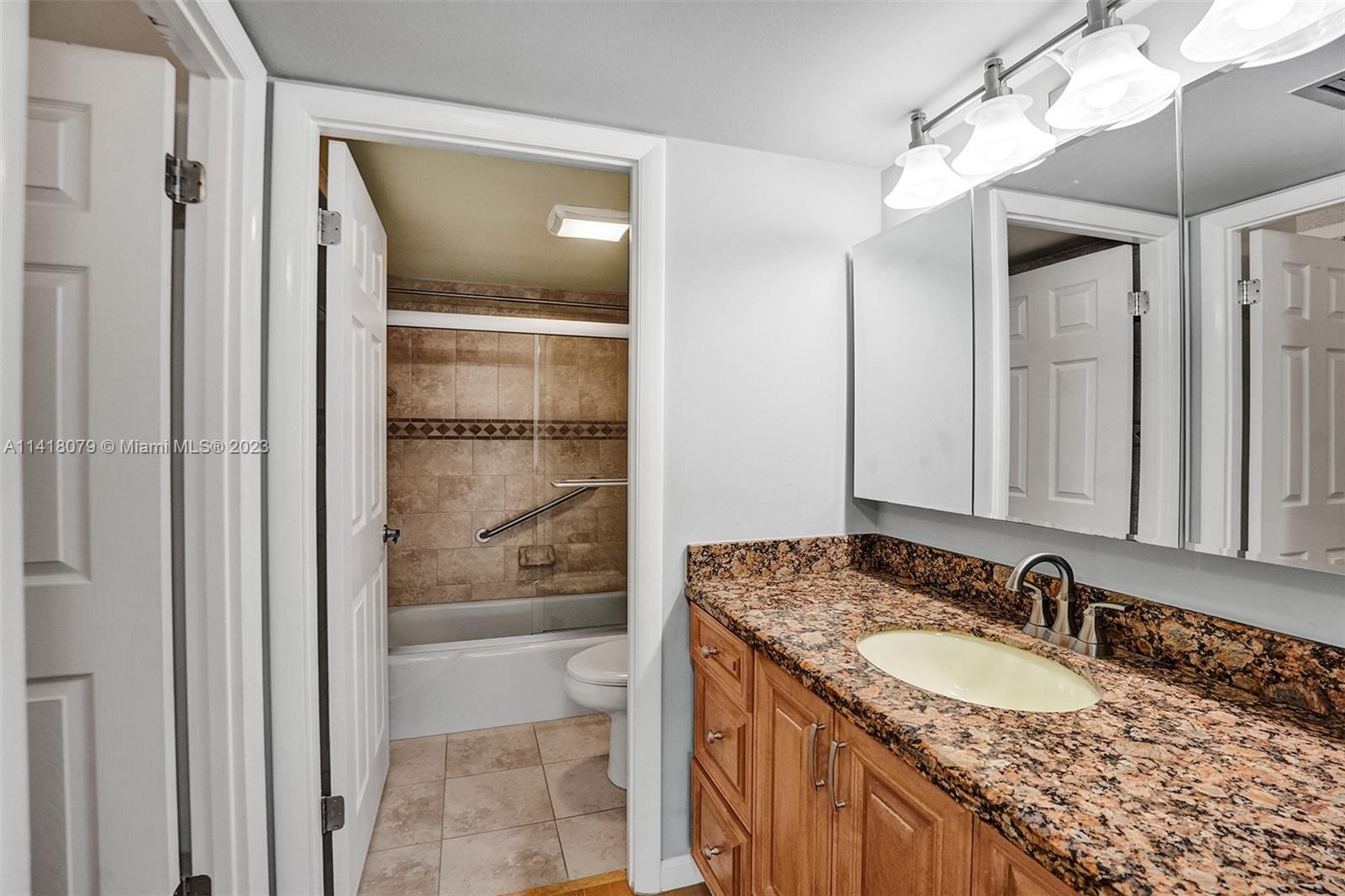 10777 West Sample Road, Unit 614 Coral Springs, FL 33065 - Photo 26 of 40 a bathroom with a granite countertop sink and a mirror