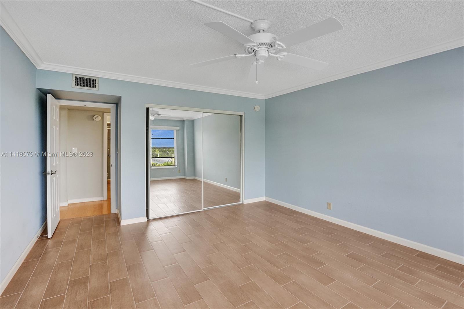 10777 West Sample Road, Unit 614 Coral Springs, FL 33065 - Photo 31 of 40 wooden floor in an empty room with a window