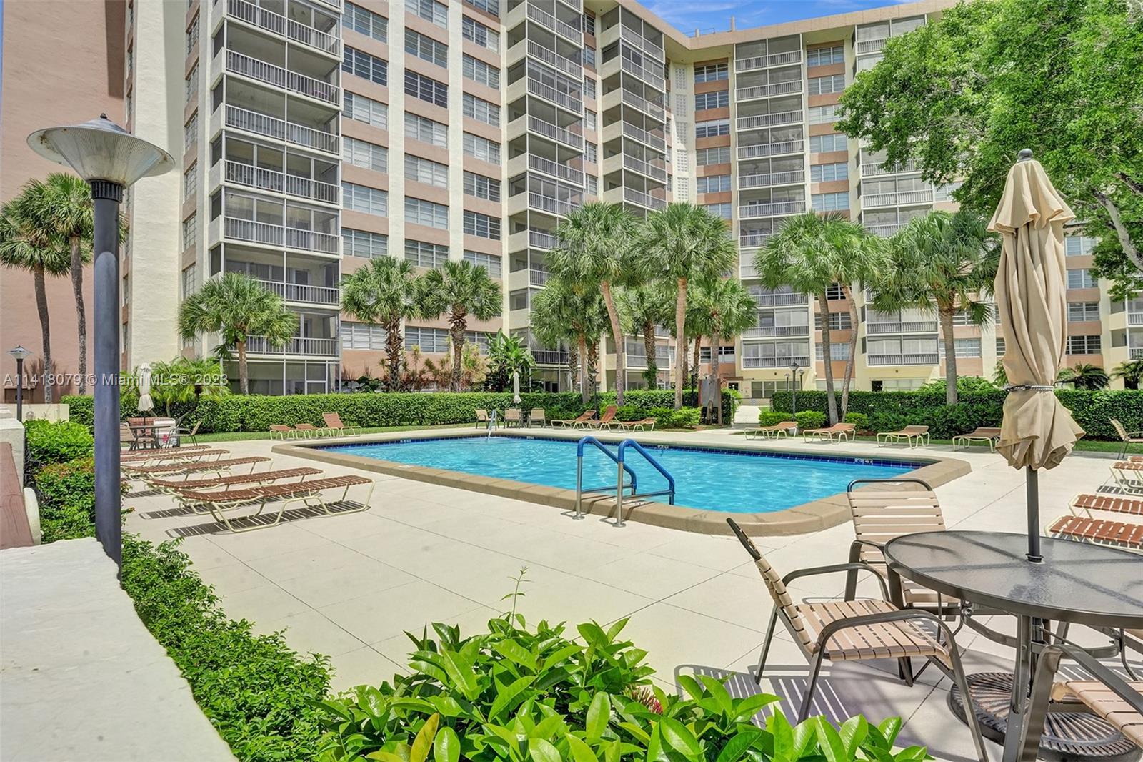 10777 West Sample Road, Unit 614 Coral Springs, FL 33065 - Photo 6 of 40 a view of swimming pool with outdoor seating and plants