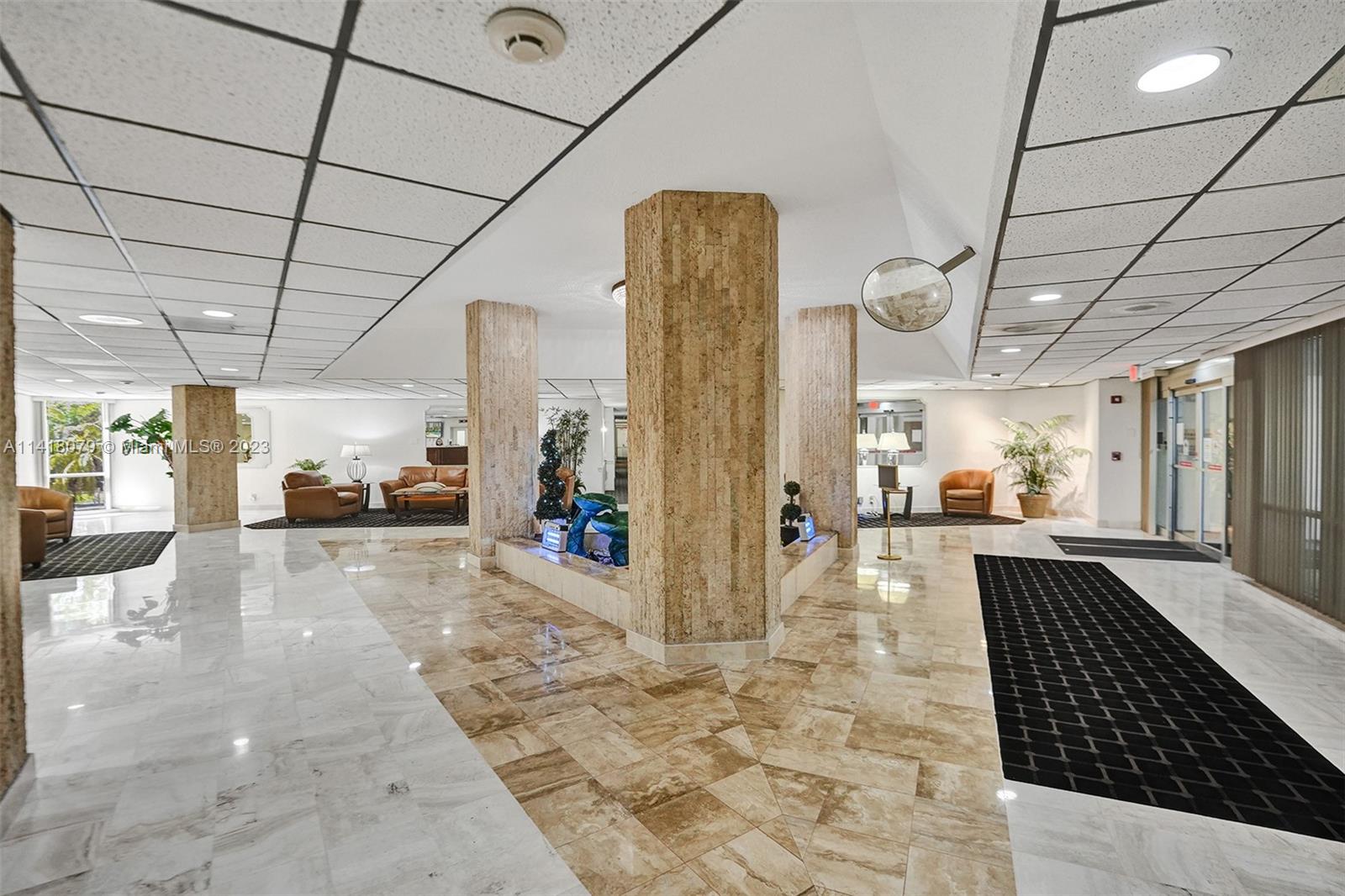 10777 West Sample Road, Unit 614 Coral Springs, FL 33065 - Photo 7 of 40 a lobby with furniture and a rug