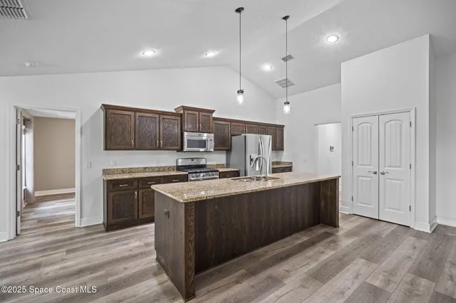 a kitchen with a counter top space a sink appliances and a large window