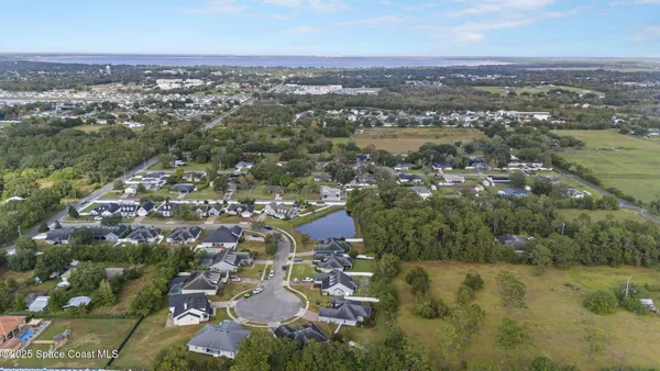 an aerial view of residential houses with outdoor space and lake view