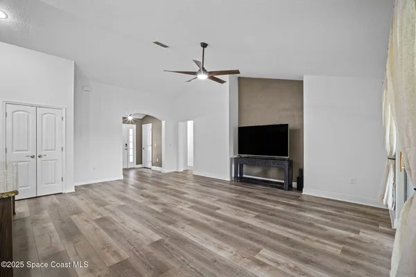a large kitchen with stainless steel appliances granite countertop a large counter top a sink a refrigerator and a stove