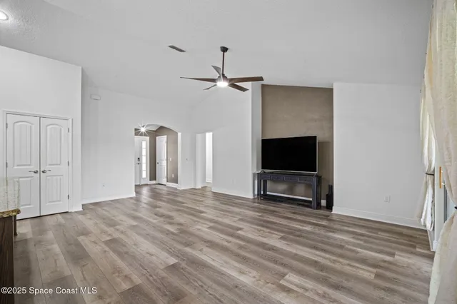 a large kitchen with stainless steel appliances granite countertop a large counter top a sink a refrigerator and a stove