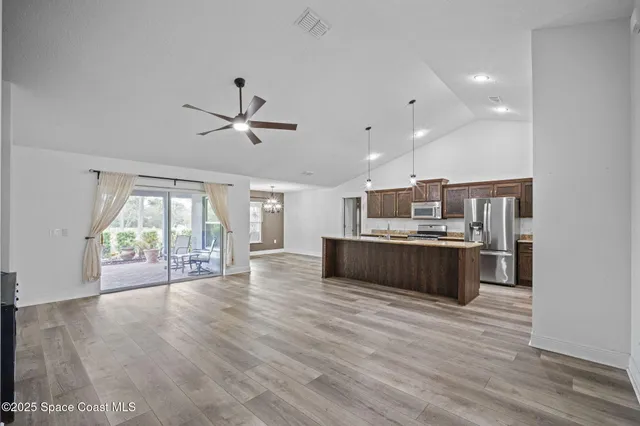 a large kitchen with kitchen island a counter space a sink stainless steel appliances and cabinets