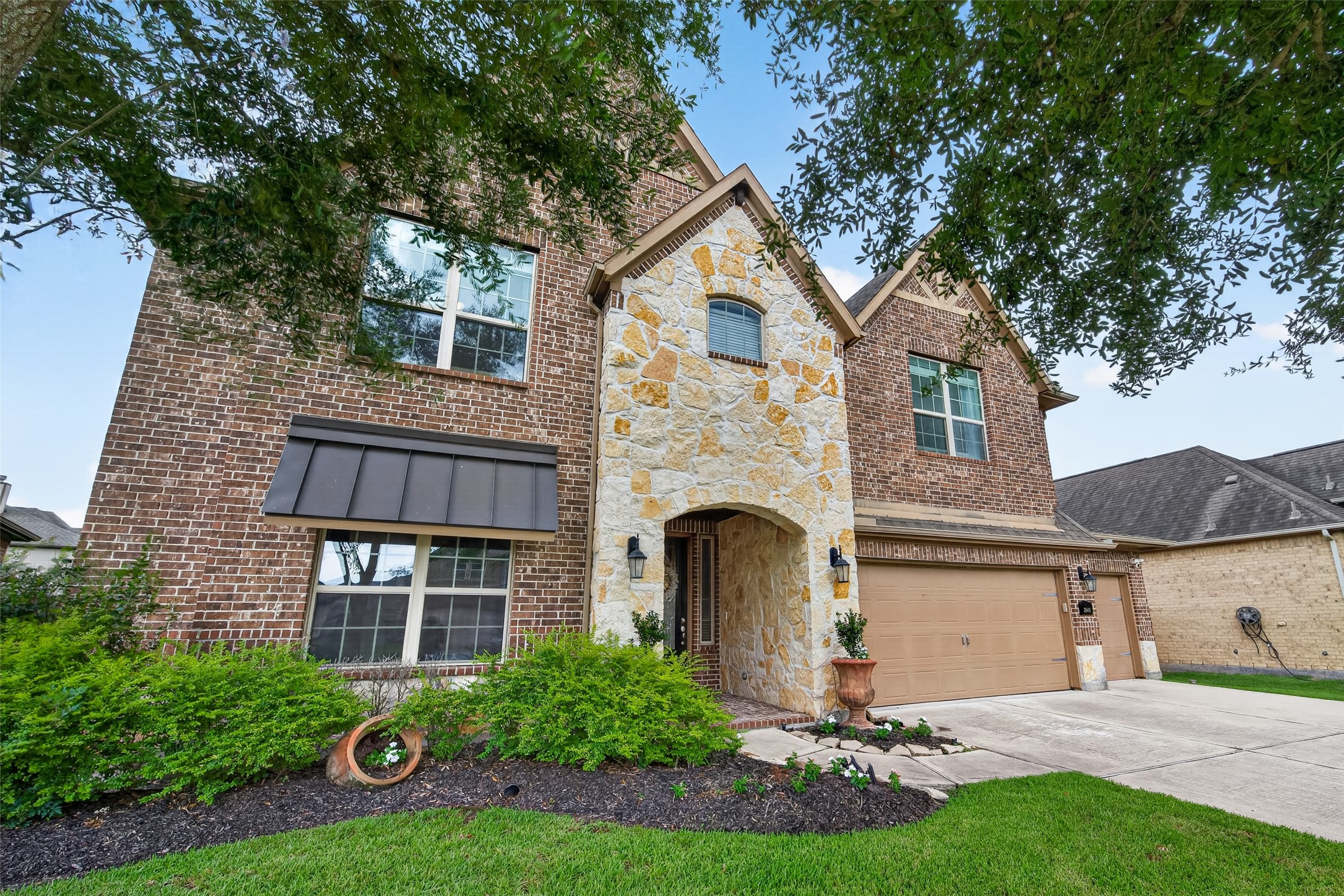 25611 Ellis Ridge Court Katy, TX 77494 - Photo 2 of 49 This two-story home features a charming brick and stone exterior, a spacious two-car garage, and well-maintained landscaping in the front yard. The large windows offer plenty of natural light, and the arched entryway adds a welcoming touch.