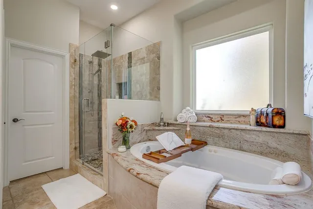 a bathroom with a granite countertop sink a mirror and shower