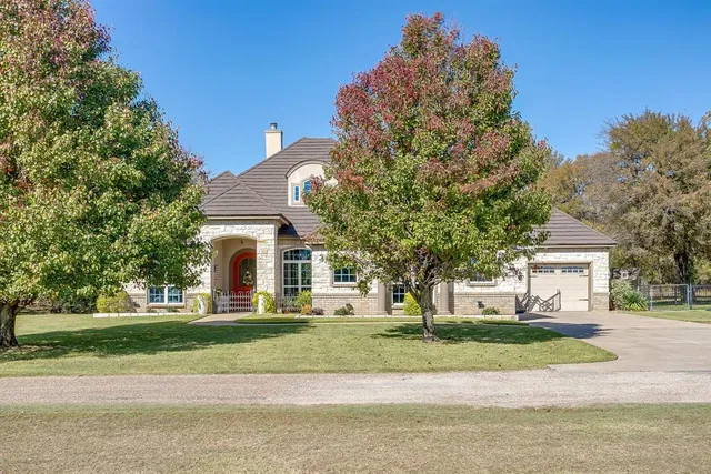 a front view of a house with yard and green space