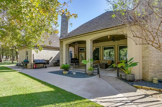 a view of a house with a big yard and large trees