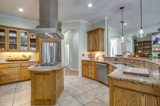 a kitchen with stainless steel appliances granite countertop a stove a sink and a refrigerator