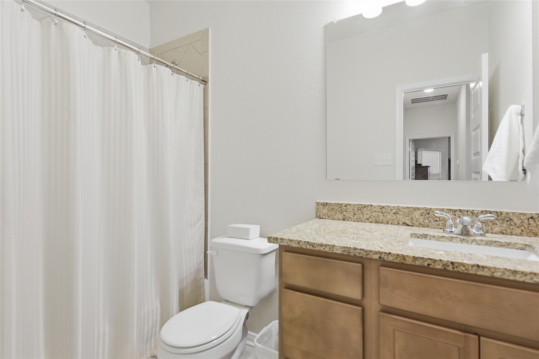 1443 Lk Rdg Drive Brenham, TX 77833 - Photo 10 of 17 a bathroom with a granite countertop sink toilet and mirror
