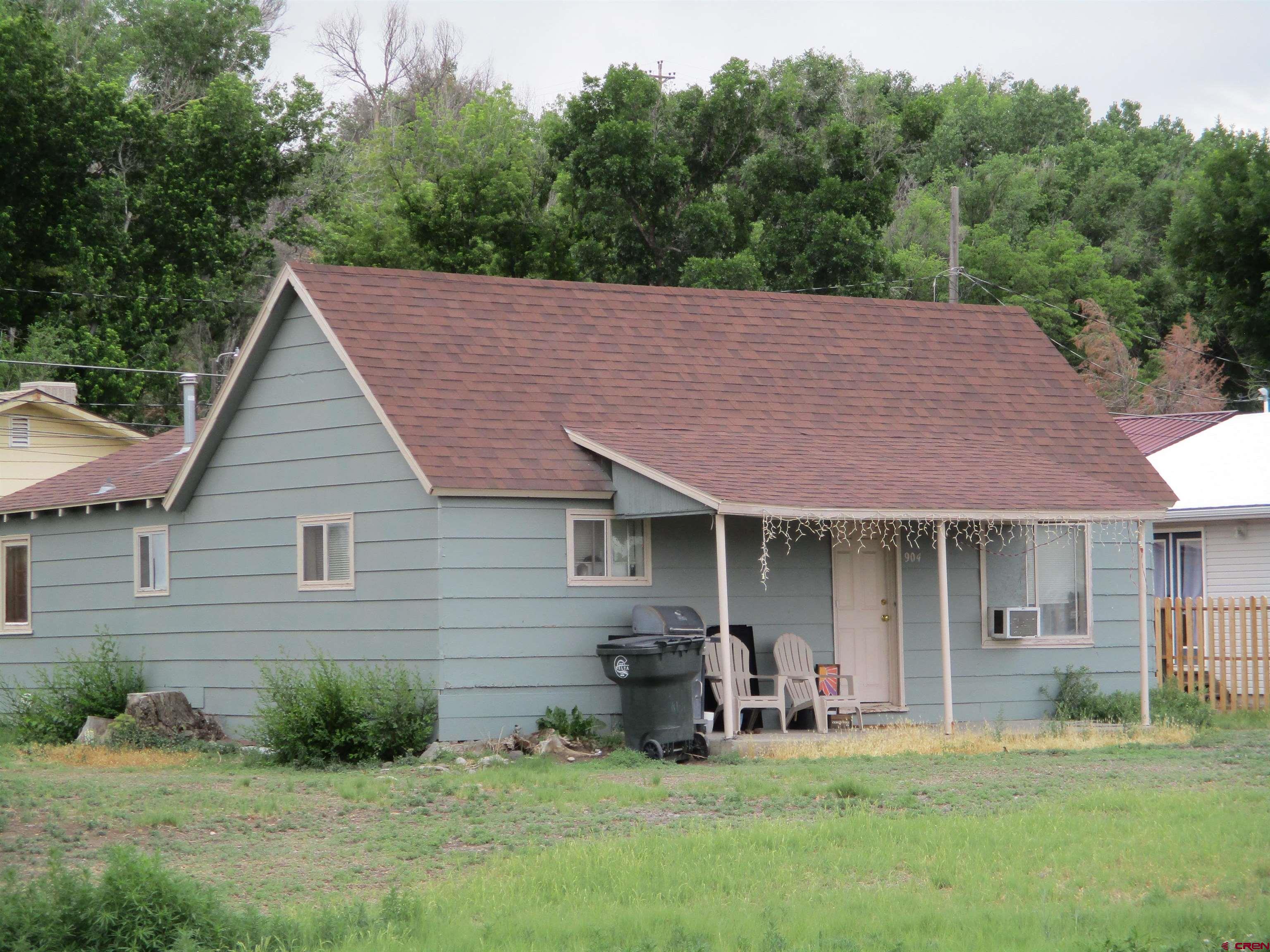 904 Bluff Street Delta, CO 81416 - Photo 1 of 1 a front view of a house with a yard and trees