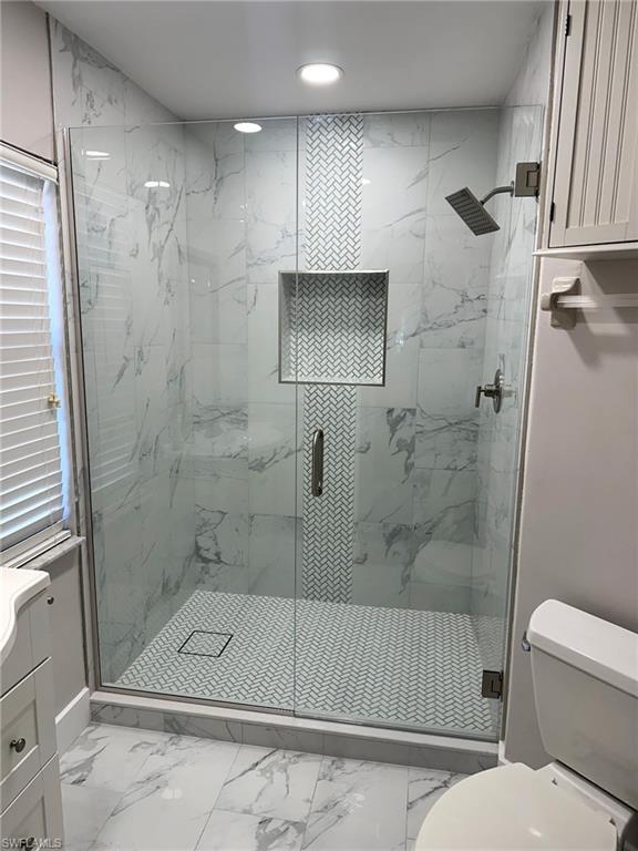 78 Bennington Drive, Unit 58 Naples, FL 34104 - Photo 17 of 24 a bathroom with a shower a toilet and a sink