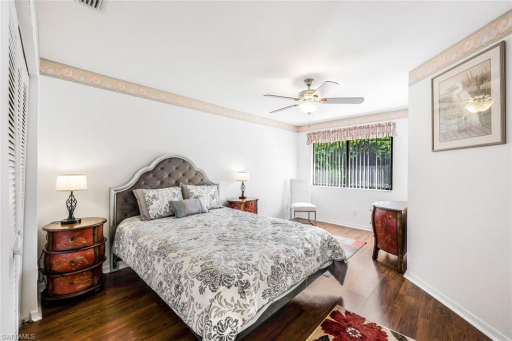 78 Bennington Drive, Unit 58 Naples, FL 34104 - Photo 18 of 24 a bedroom with a bed and a chandelier