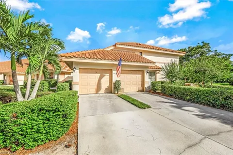 a front view of a house with a yard and potted plants