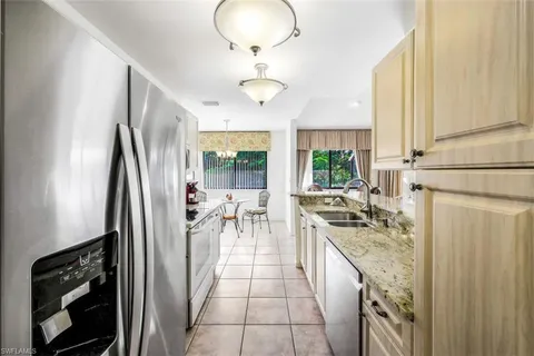 a kitchen with stainless steel appliances granite countertop a stove refrigerator and cabinets