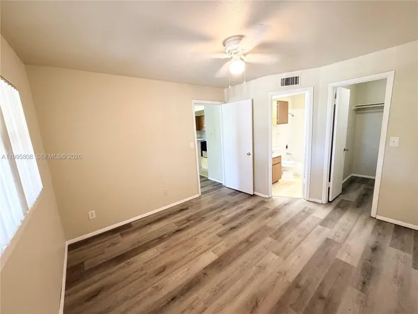 a view of an empty room with wooden floor