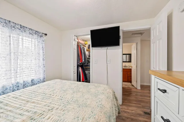 a large bed sitting in a bedroom next to a window