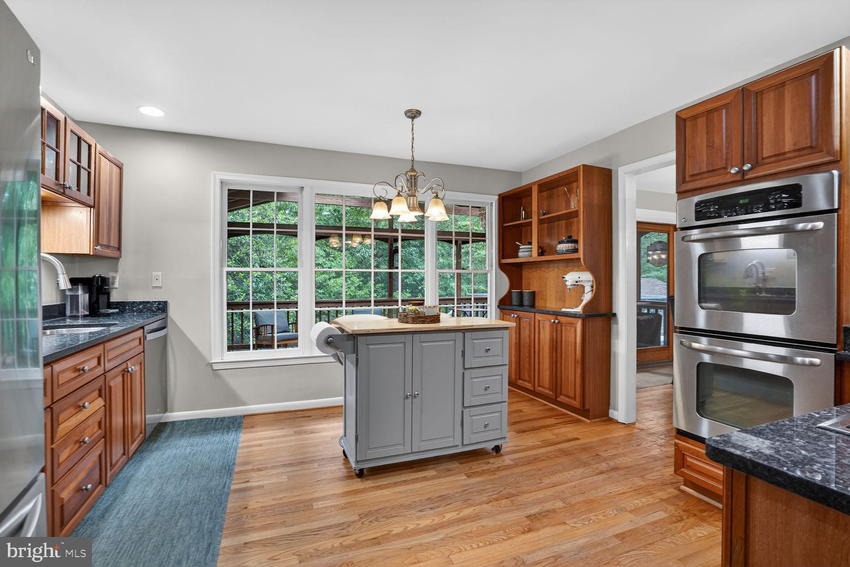 5024 Portsmouth Road Fairfax, VA 22032 - Photo 13 of 38 a kitchen with granite countertop a stove top oven a sink dishwasher and wooden cabinets with wooden floor