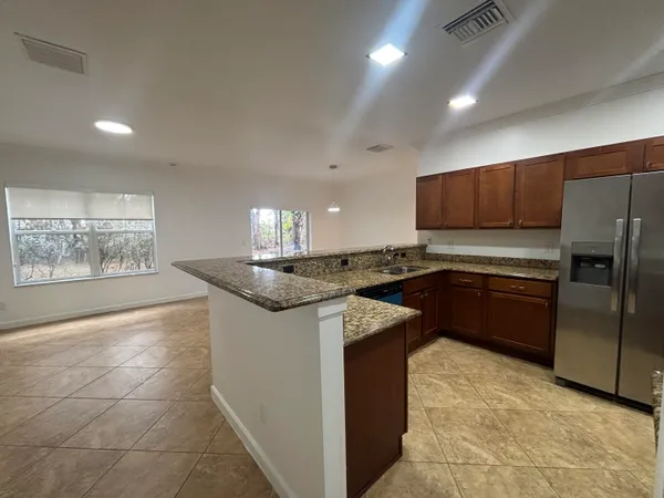 a kitchen with granite countertop a stove and a refrigerator