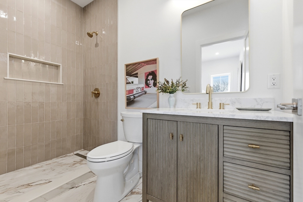 51 Fox Hill Road Nahant, MA 01908 - Photo 21 of 36 a bathroom with a granite countertop sink a toilet a mirror and shower