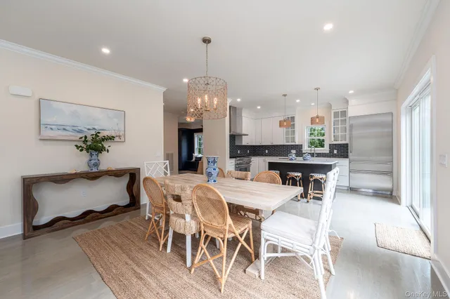a dining room with furniture a chandelier and wooden floor